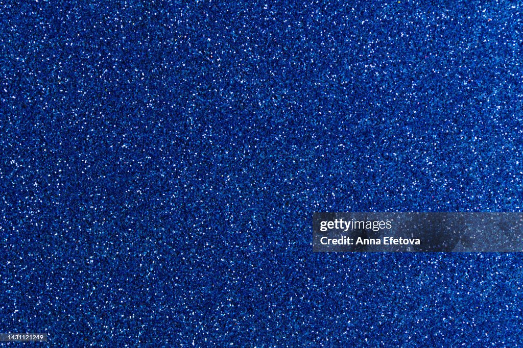 Festive navy blue glittering background. New Year and Christmas celebration concept. Bright backdrop for your design with copy space.