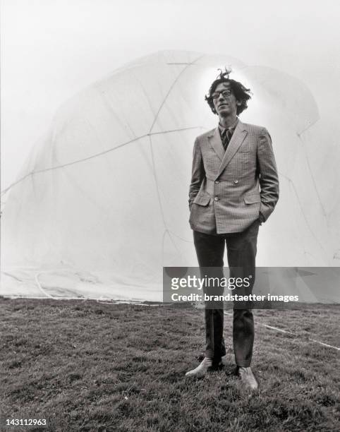 Artist Christo at the documenta IV in Kassel, Germany. In the background his work 5450 m cubic package. Photograph. 1968.