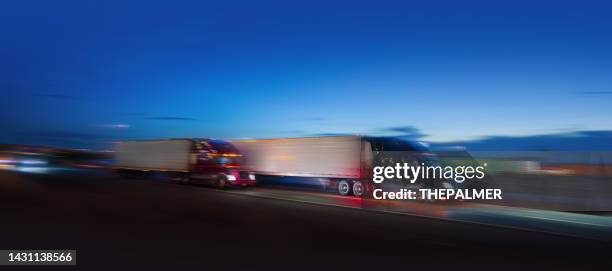 two semi-truck sdriving on the highway at night - motion blur - moving truck stockfoto's en -beelden