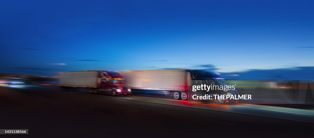 Two semi-truck sdriving on the highway at night - motion blur