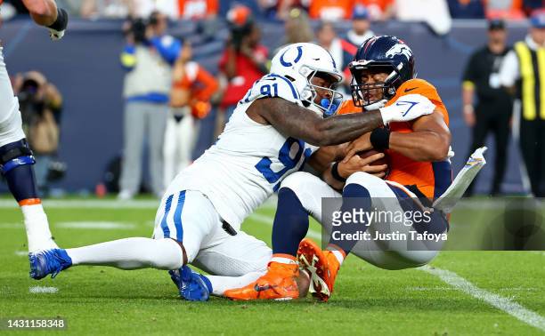 Russell Wilson of the Denver Broncos is sacked by Yannick Ngakoue of the Indianapolis Colts during a game at Empower Field At Mile High on October...