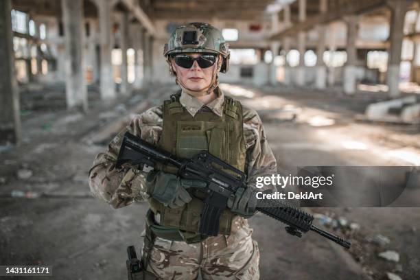 portrait d’une femme soldat en uniforme de camouflage tenant un fusil en patrouille dans une zone de guerre - stealth stock photos et images de collection