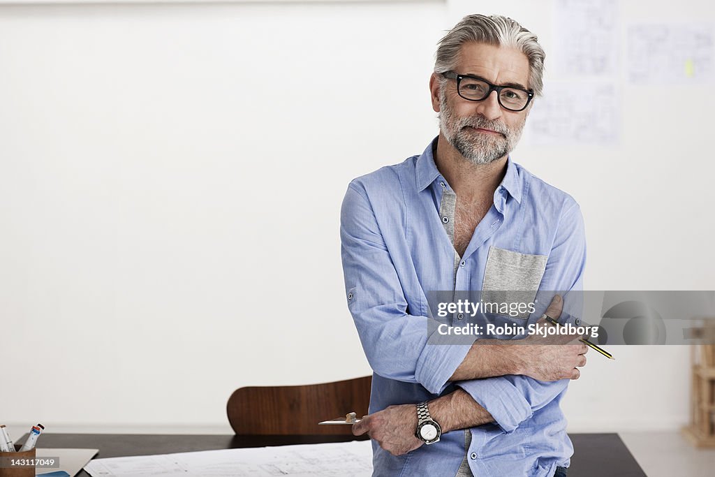 Portrait of creative mature man working on sketch