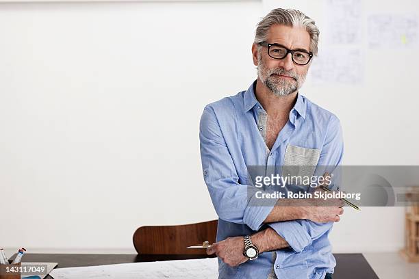 portrait of creative mature man working on sketch - gray hair stock-fotos und bilder