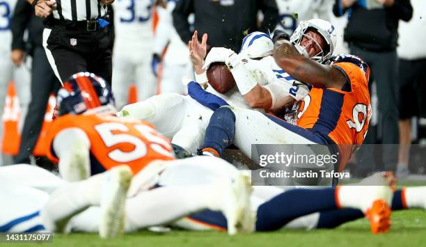 Matt Ryan of the Indianapolis Colts is sacked by Dre'Mont Jones of the Denver Broncos during a game at Empower Field At Mile High on October 06, 2022...