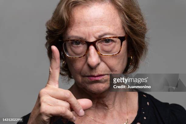 serious senior woman front mugshot scolding pointing at you - angry women stock pictures, royalty-free photos & images