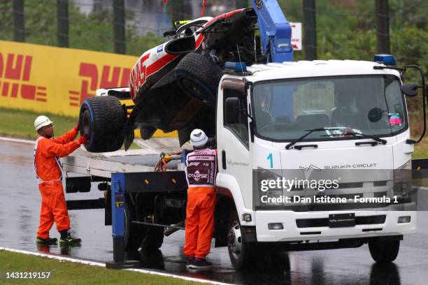 The car of Mick Schumacher of Germany and Haas F1 is collected from the track after a crash during practice ahead of the F1 Grand Prix of Japan at...