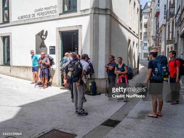 Pilgrims are seen waiting outside of an Albergue after walking one of the stages of the Camino Primitivo. In Lugo, on May 29th, 2023.