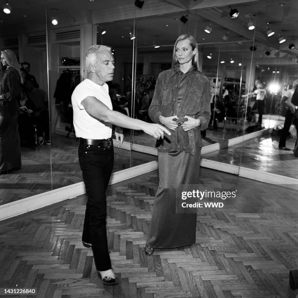 Designer Ralph Lauren adjusts garment on model.