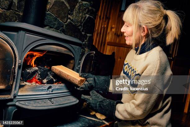 wood burning stove - stoking 個照片及圖片檔