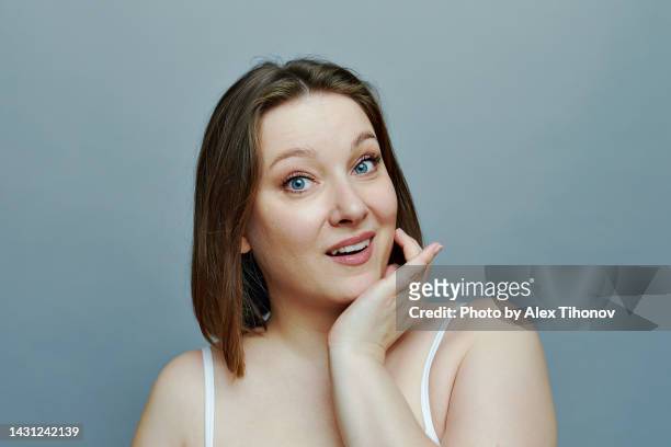 surprised plus size woman staring at camera, studio shot, headshot portrait - chubby face stockfoto's en -beelden