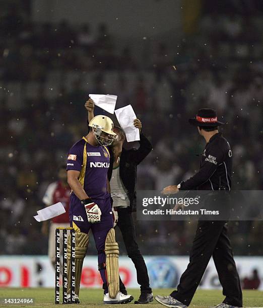 Pitch invader throws papers on a player during the IPL20 match between Kings XI Punjab and Kolkata Knight Riders at PCA cricket Stadium on April 18,...