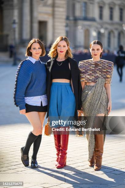 A guest wears a baby blue shirt, a blue ribbed wool with embroidered black straps sleeves pullover, a black short skirt, black socks, black shiny...