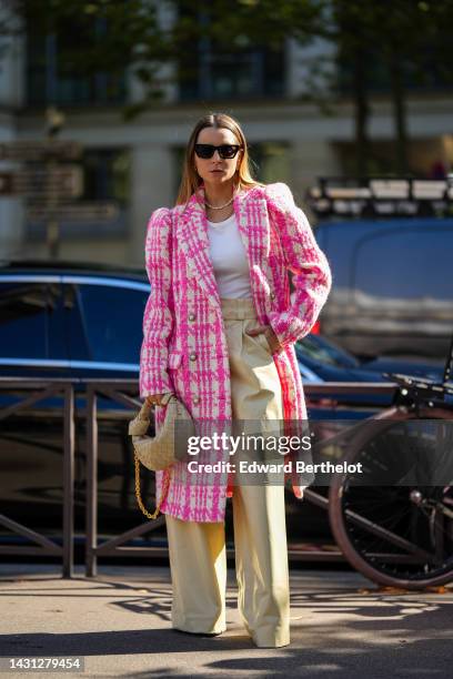 Julia Comil wears black sunglasses, gold earrings, a white pearls necklace, a gold large chain necklace, a white tank-top, a white and pink...