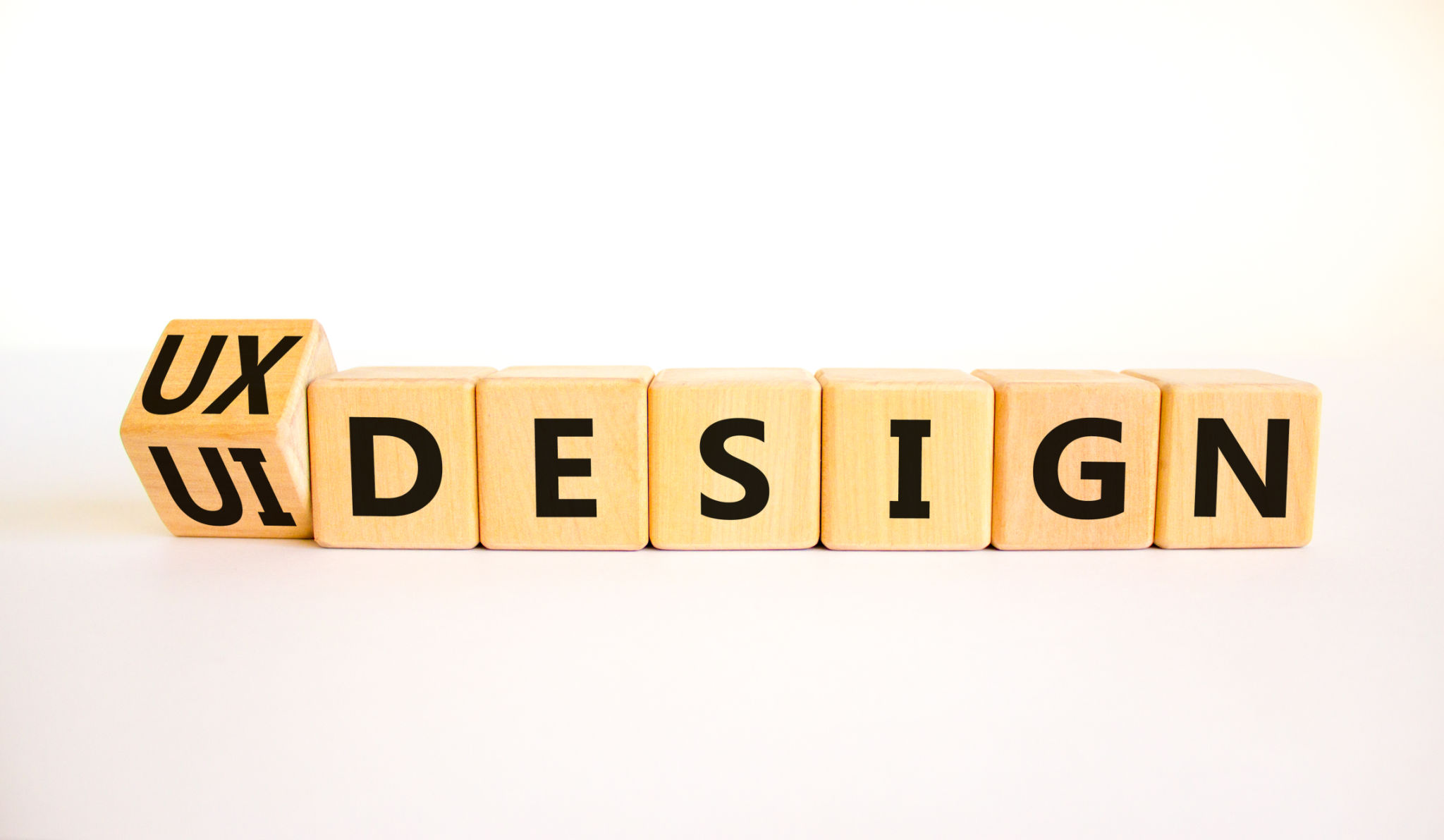 UX user experience design or UI user interface design symbol. Turned wooden cubes and changed words UX design to UI design. Beautiful white background. Business UX or UI design concept. Copy space. UX user experience design or UI user interface design symbol. Turned wooden cubes and changed words UX design to UI design. Beautiful white background. Business UX or UI design concept. Copy space.