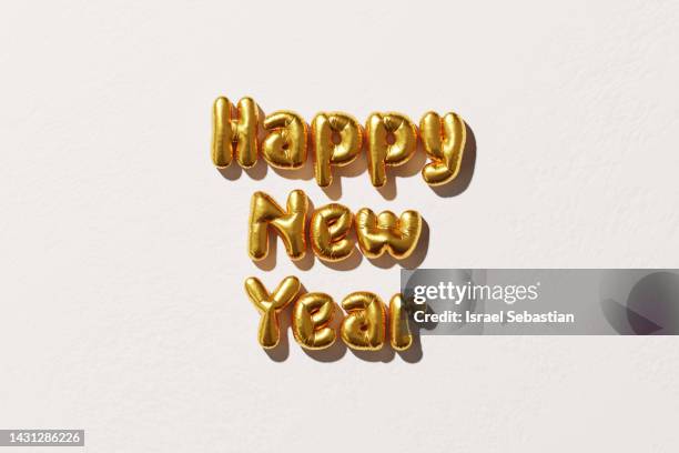 digitally generated image of golden metallic balloons forming the text "happy new year" on white background. christmas concept. - happy new month stockfoto's en -beelden