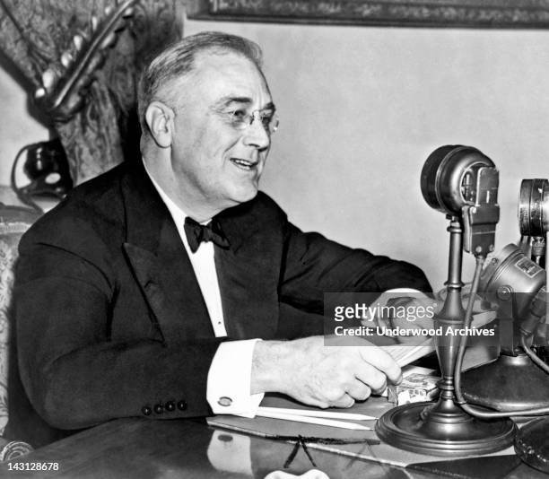 President Franklin D. Roosevelt, seated behind microphone, during one of his fireside chats, Washington DC, 1937.