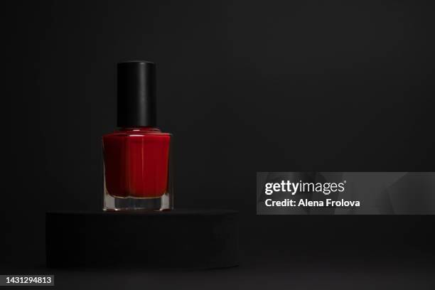 red nail polish on black background - red nail polish stockfoto's en -beelden