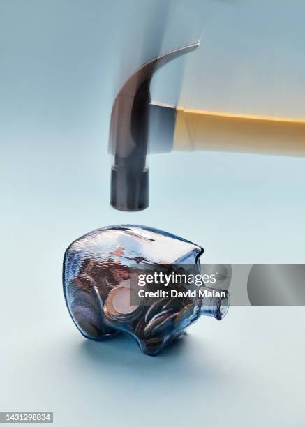 a glass piggy bank on a paper surface with a hammer about to hit it. - breaking habits ストックフォトと画像