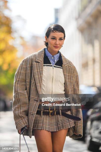 Alyssa Coscarelli wears a blue striped print pattern shirt, a navy blue and white bicolored braided wool zipper pullover from Miu Miu, a beige with...