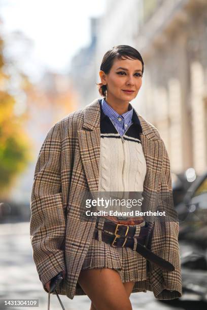Alyssa Coscarelli wears a blue striped print pattern shirt, a navy blue and white bicolored braided wool zipper pullover from Miu Miu, a beige with...