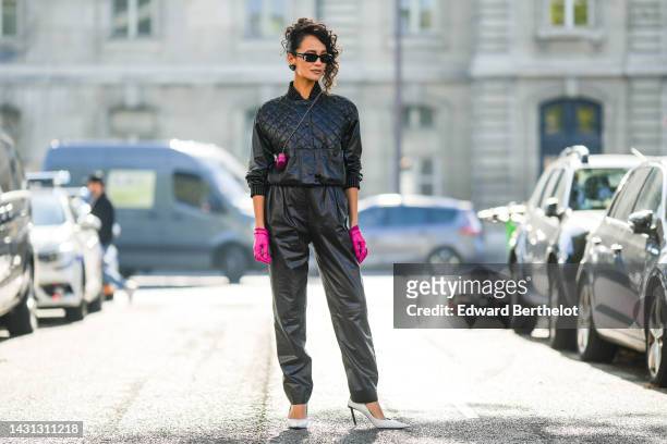 Anna Rosa Vitiello wears black sunglasses from Chanel, black shiny leather heart logo earrings from Chanel, a black shiny leather quilted jacket from...