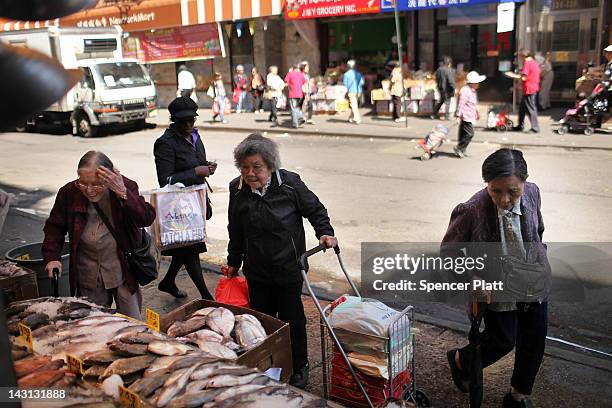 Elderly women walk by a fish market April 19, 2012 in the Chinatown neighborhood of New York City. According to an analysis by the city's Center for...