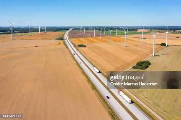 trucks with trailers in an agricultural landscape with wind turbines - convoy 個照片及圖片檔