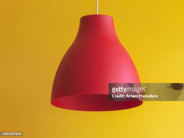 hanging red lampshade on a yellow background - lamp shade imagens e fotografias de stock