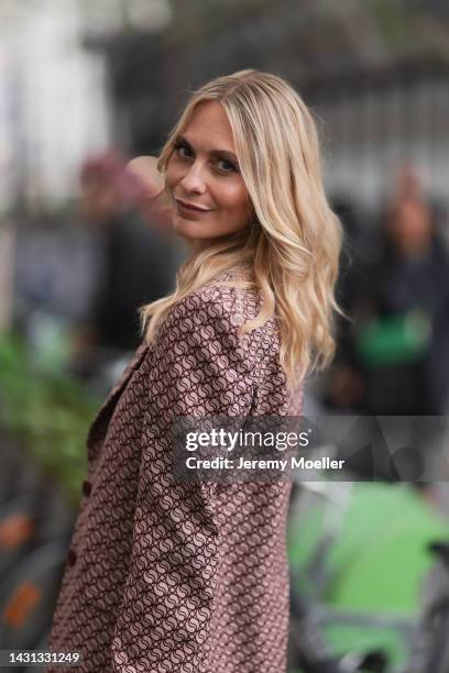 Poppy Delevingne seen wearing a matching red patterned suit, outside Stella McCartney during Paris Fashion Week on October 03, 2022 in Paris, France.