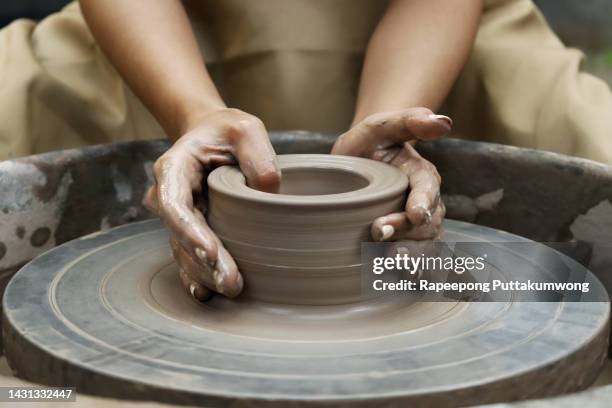 women working on the potter's wheel. hands sculpts a cup from clay pot. workshop on modeling on the potter's wheel - sculptor fotografías e imágenes de stock