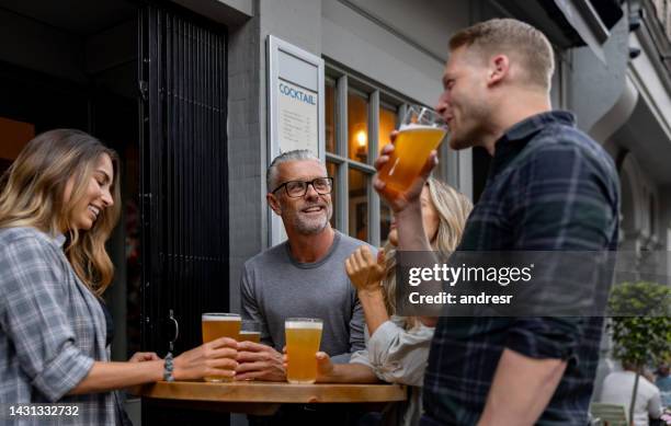 happy friends having fun drinking at the pub - english pub stock pictures, royalty-free photos & images