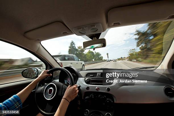 a female driving on a highway. - lenkrad stock-fotos und bilder