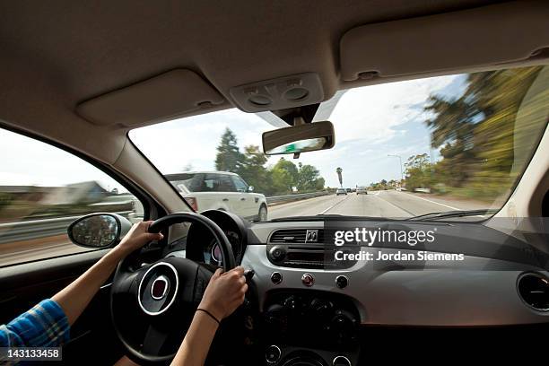 a female driving on a highway. - salpicadero coche fotografías e imágenes de stock