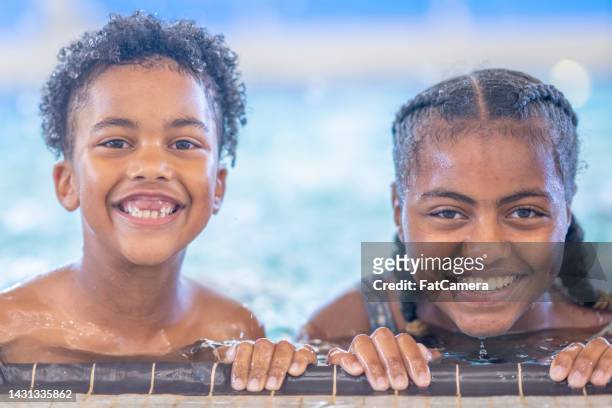 lächelnde kinder schwimmen - young girl swimsuit stock-fotos und bilder