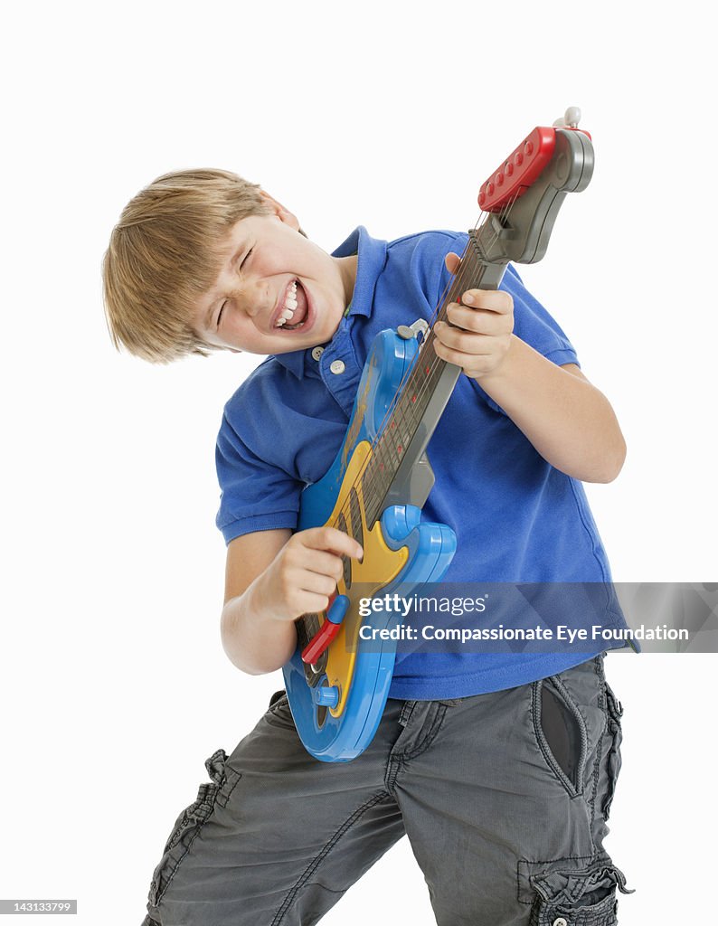 Boy (8-9) playing guitar, studio shot