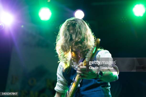 young adult man playing electric guitar on music stage - pop musician stock pictures, royalty-free photos & images