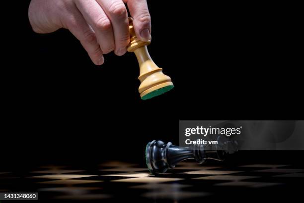 player moving pieces on chessboard - chess defeat stock pictures, royalty-free photos & images