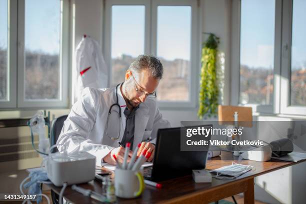 männlicher arzt, der in seiner praxis arbeitet - ordination stock-fotos und bilder