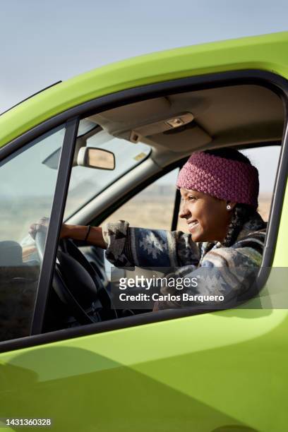 vertical photo of a beautiful and confident young woman on road trip driving a green van. - mini van driving stock pictures, royalty-free photos & images