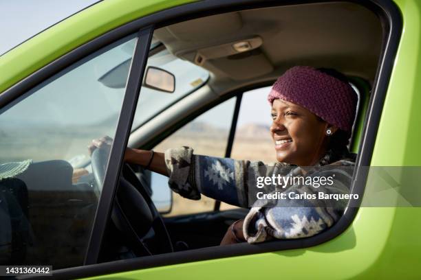 beautiful and confident young woman on road trip driving a green van. - mini van driving stock pictures, royalty-free photos & images