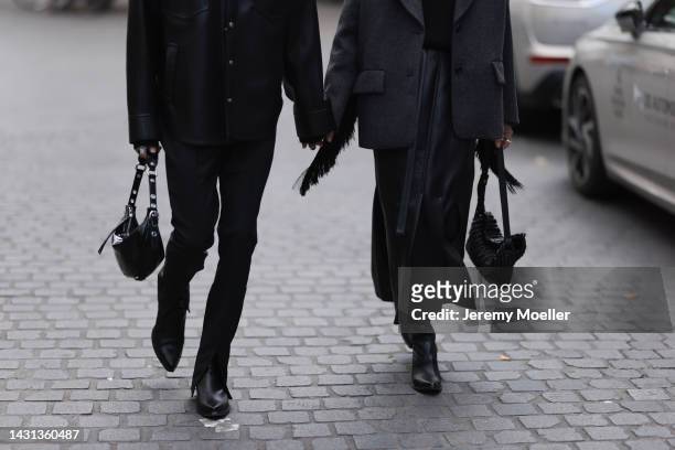 Simon Nygard is seen wearing black t-shirt, black leather shirt jacket, black suit pants, black leather boots and a black leather handbag; Ilenia...