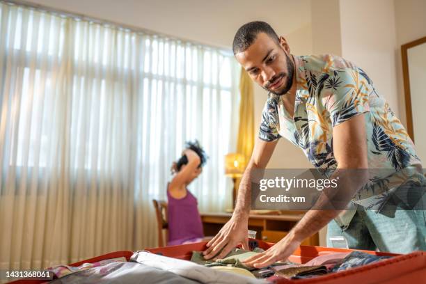 couple packing suitcase in hotel room, medium shot - indian honeymoon couples stock pictures, royalty-free photos & images