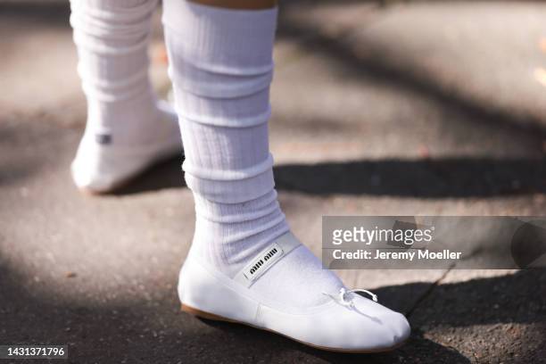 Shoe detail of a fashion week guest wearing white socks and white Miu Miu leather ballerinas outside Miu Miu during Paris Fashion Week on October 4,...