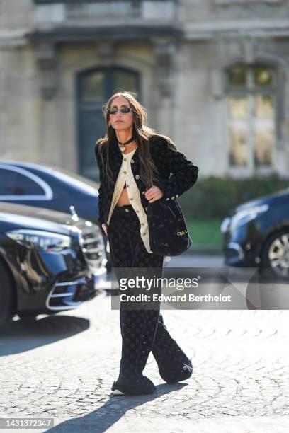 Chloe Harrouche wears black sunglasses, diamonds logo earrings from Chanel, a black with gold heart pendant earrings from Chanel, a white lace flower...