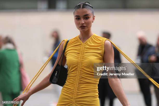 Fashion week guest is seen wearing a yellow dress, outside Stella McCartney during Paris Fashion Week on October 03, 2022 in Paris, France.