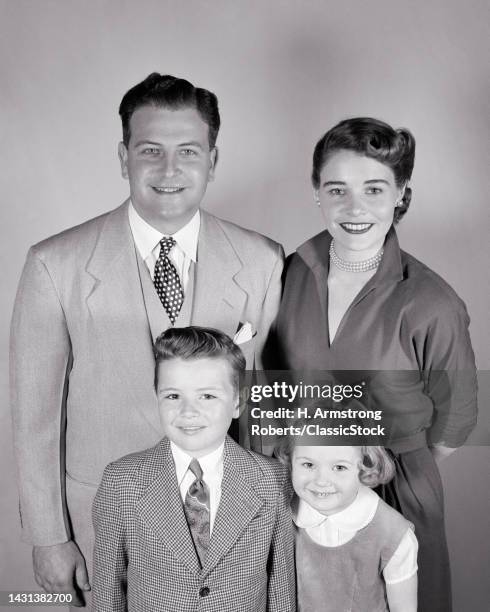 Portrait of a family, including a father, mother, son, & daughter, as they smile at the camera, March 13, 1951.