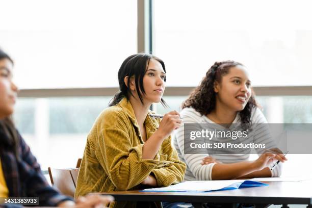 serious young adult female university students watch video - american indian girls stockfoto's en -beelden