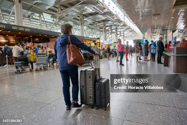 An arriving traveler waits with her luggage in the arrivals hall at Terminal 1 in Humberto Delgado International Airport Humberto Delgado...