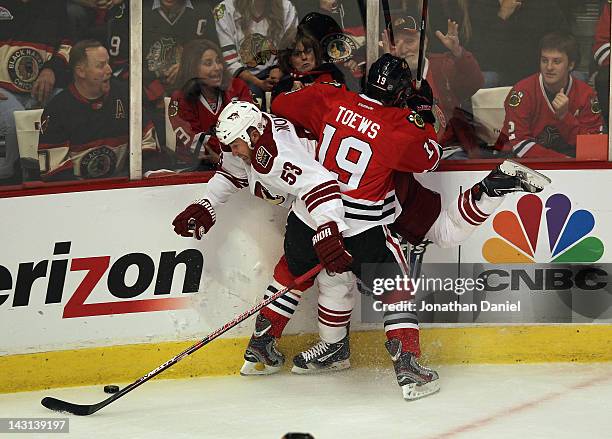 Jonathan Toews of the Chicago Blackhawks pins Derek Morris of the Phoenix Coyotes to the boards as they battle for the puck in Game Four of the...